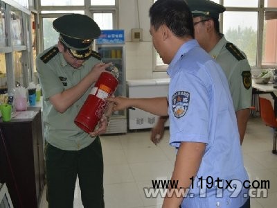 執法人員查看學校內滅火器